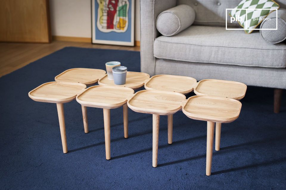 Originaler Couchtisch aus hellem Holz mit einer Anordnung von Tabletts.