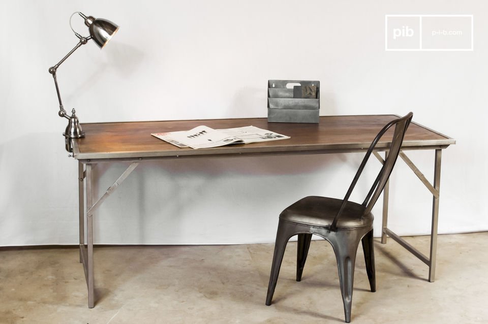 Industrieller Tisch mit Stuhl, Lampe und Retro-Objekten.