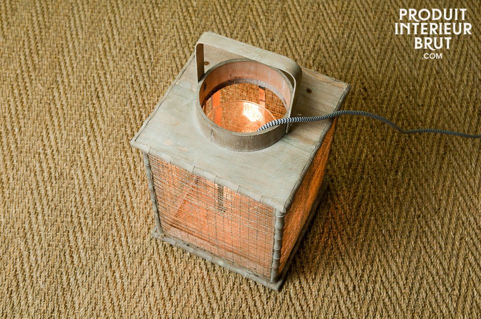 Diese originelle Laterne aus hellem lasierten Holz besteht aus einem Glasbehälter als Windschutz